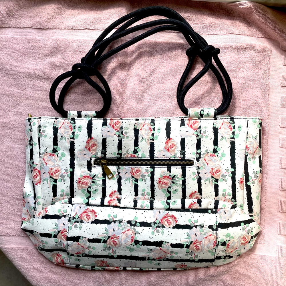 Canvas tote. Never used. 2 zipper pockets. 1 cell phone pocket inside. 18x11”.